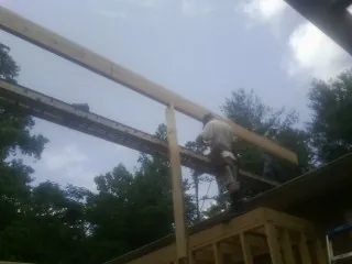 Carpenter setting a ridge beam over a new addition frame — Ice Dam Removal by Roofing Brothers in Yorktown Heights