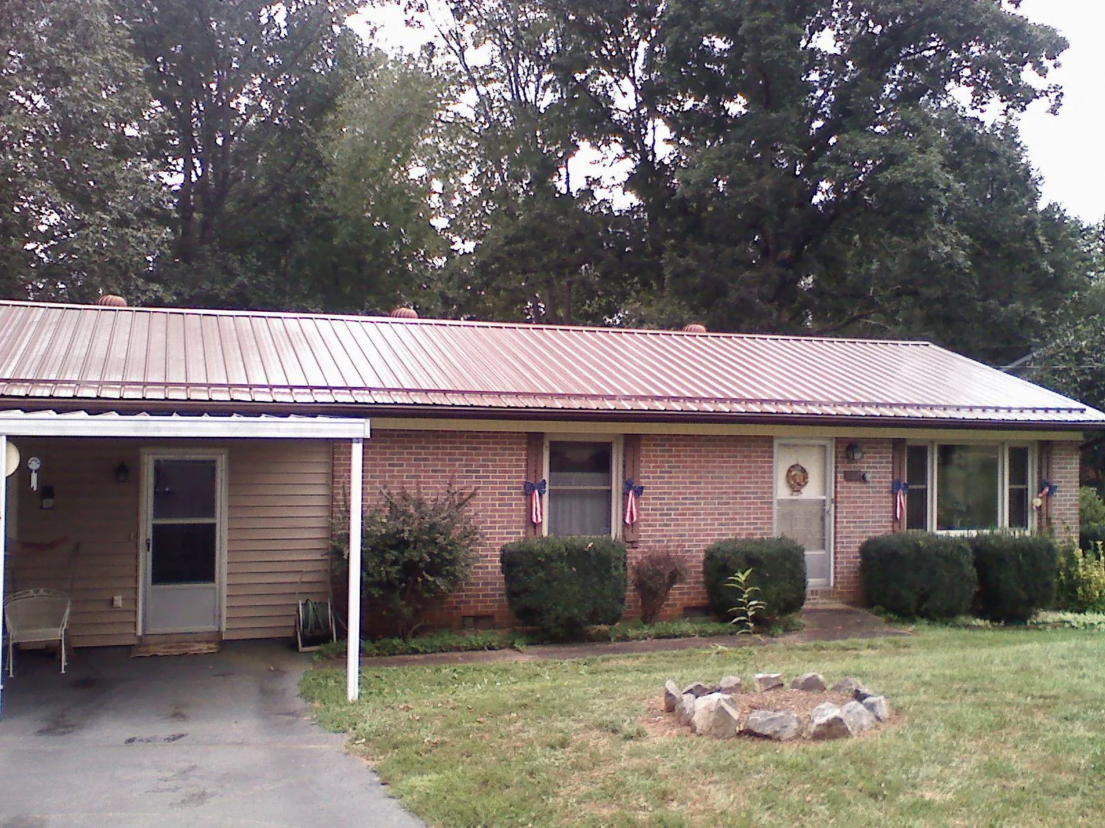 Bronze metal roof and carport on a brick ranch home — Roof Repair work by our crew in Yorktown Heights